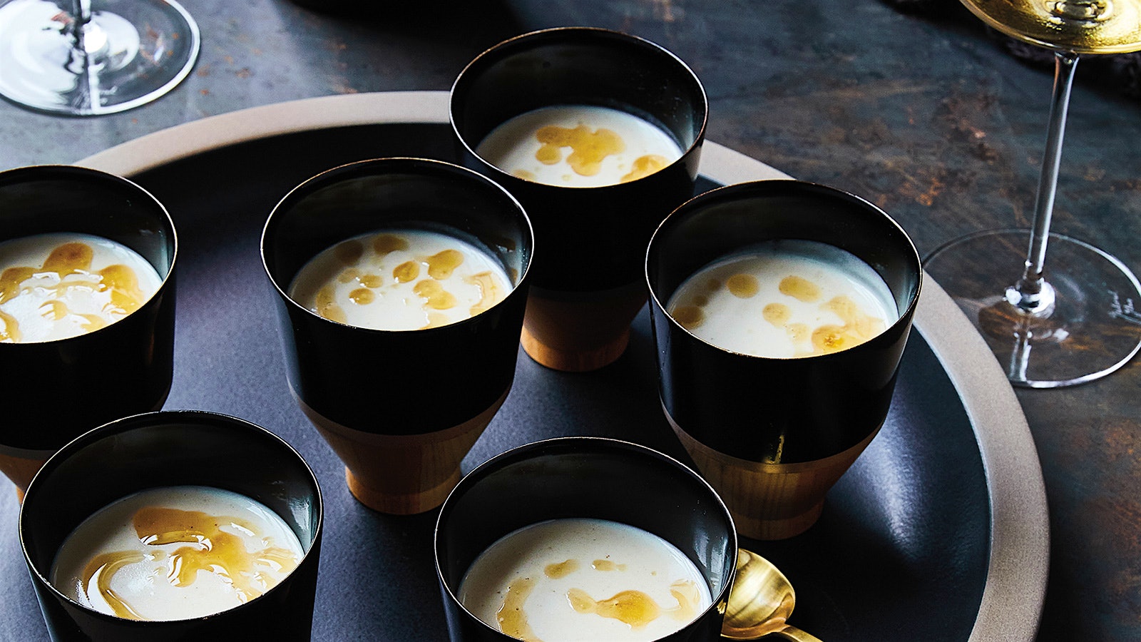 A creamy sunchoke and brown butter soup served in black demitasse cups
